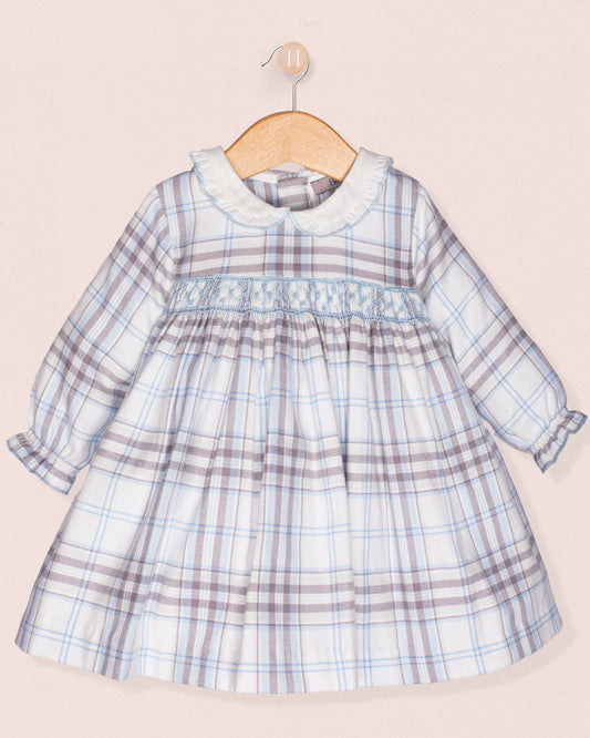 Plaid dress on a wooden hanger against a light pink background