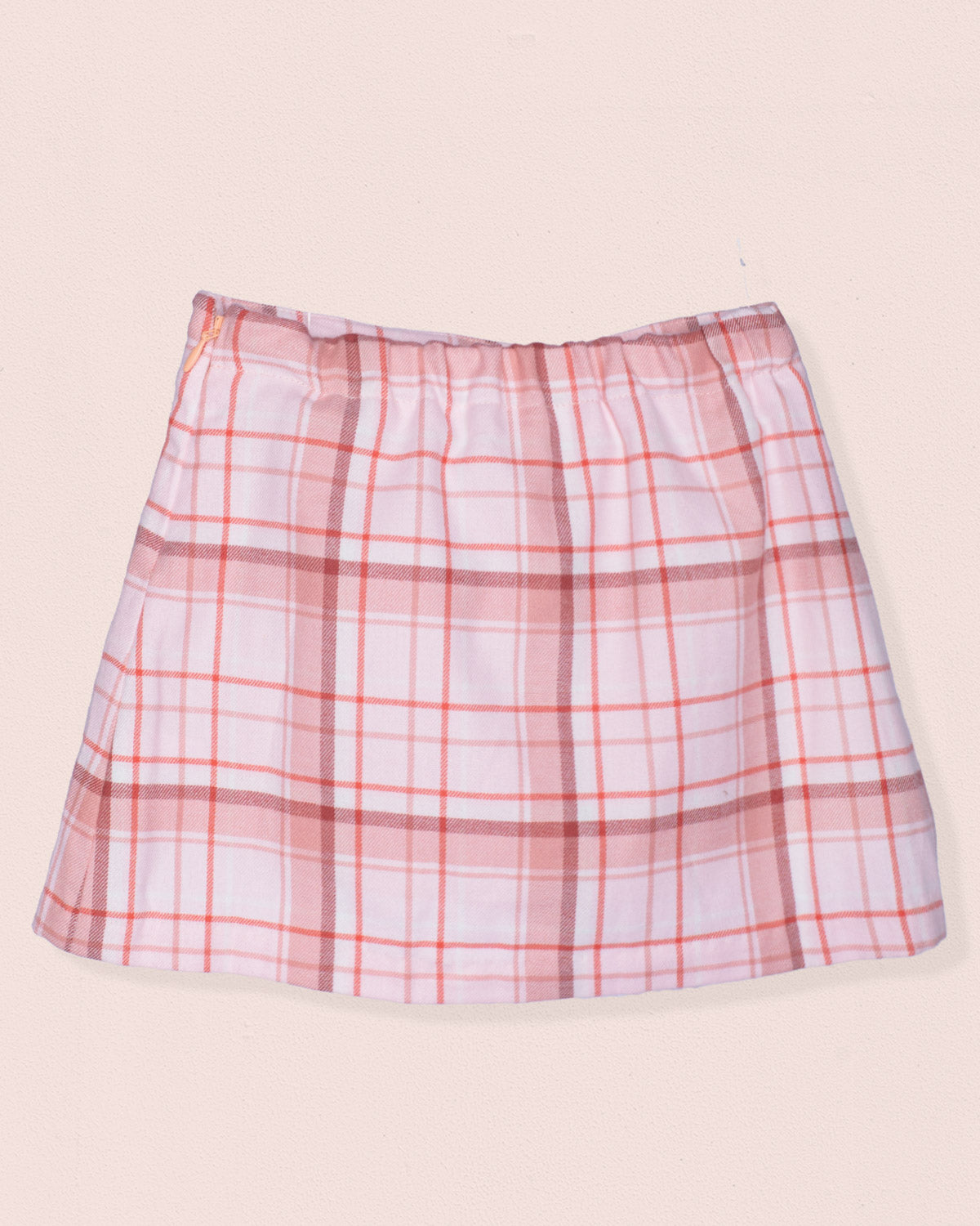 Back of plaid skirt with pink and white pattern on a beige background
