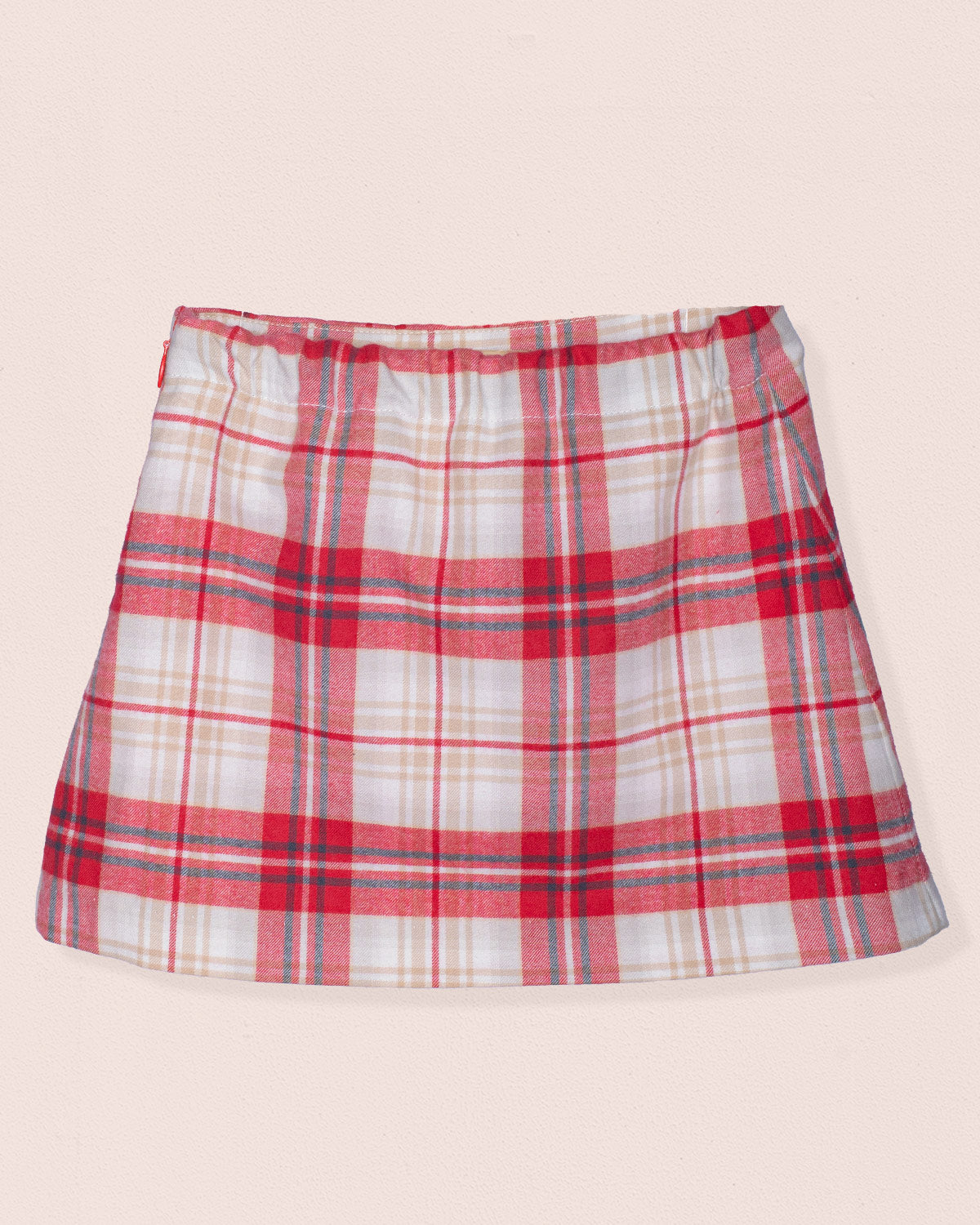 Plaid skirt with red, white, and blue pattern on a beige background
