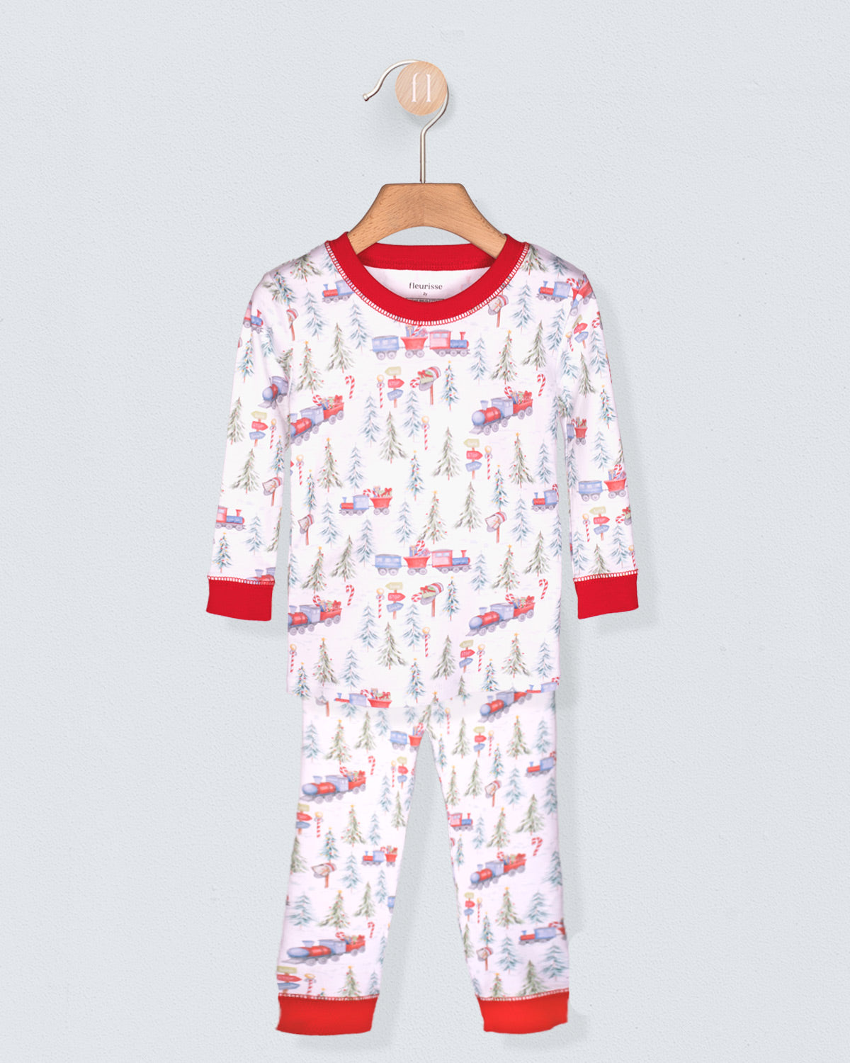 Children's pajama set with vehicle pattern on a hanger against a light gray background