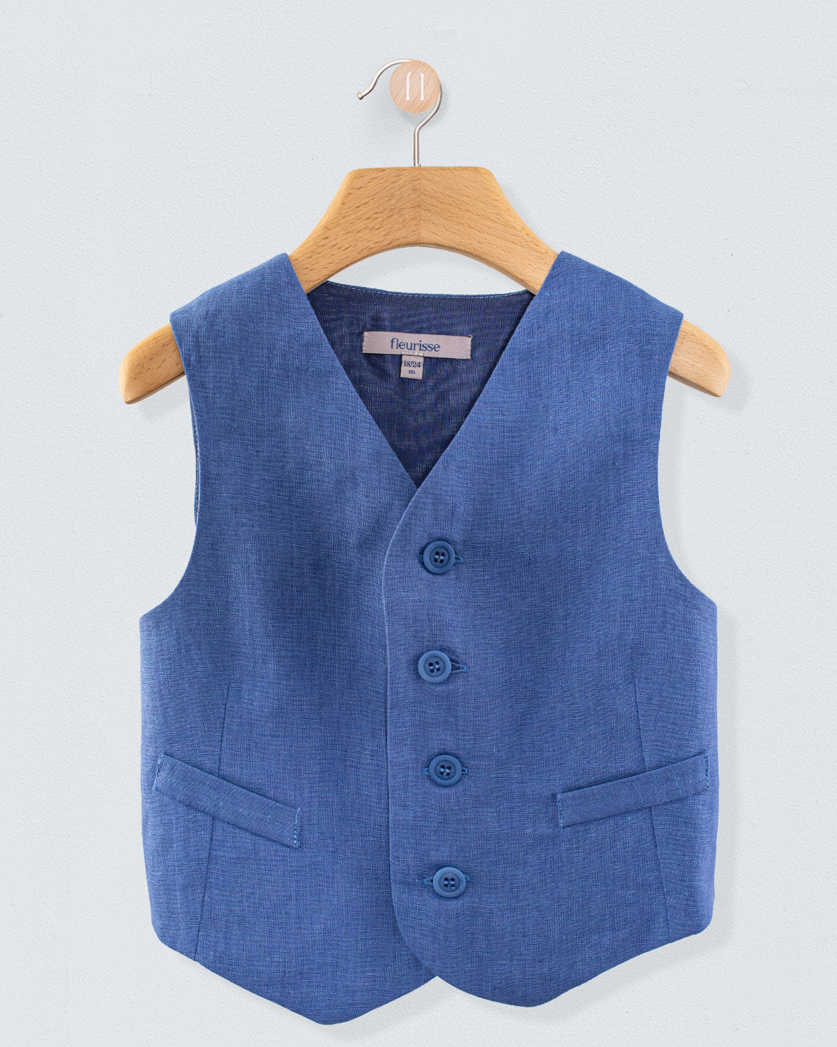 Front view of Prince Harry blue linen vest with three buttons and two pockets, displayed on a wooden hanger