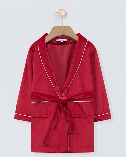 Red robe with white trim on a wooden hanger against a light gray background