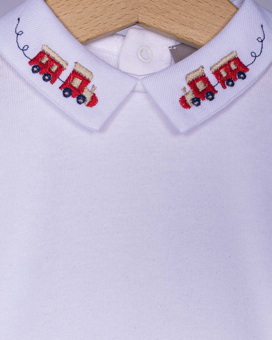 White shirt train on collar with embroidered red train design on a wooden hanger.