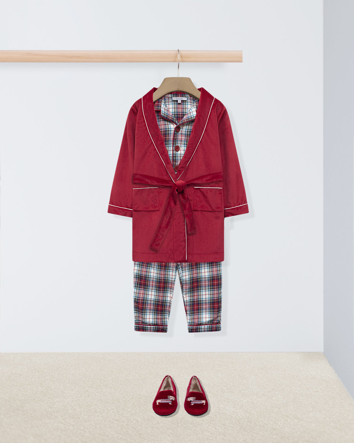 Red robe with plaid shirt and pants on a hanger, accompanied by red shoes on a white background.