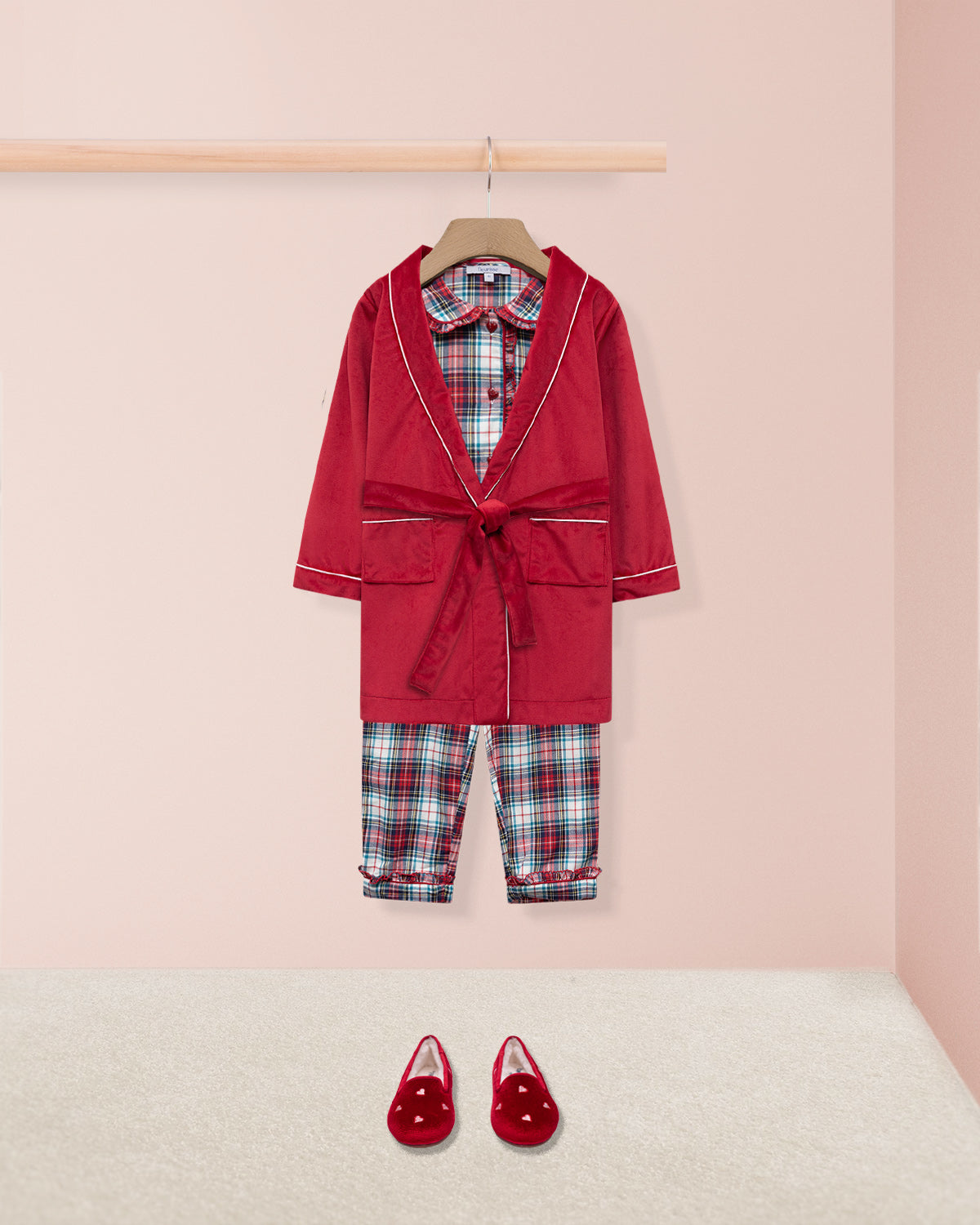 Red loungewear outfit with plaid details on a pink background with red robe and red slippers