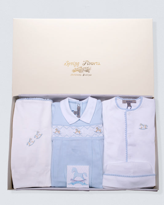 Baby boy clothing set with light blue footie white footie, and blanket in a gift box on a light gray background.