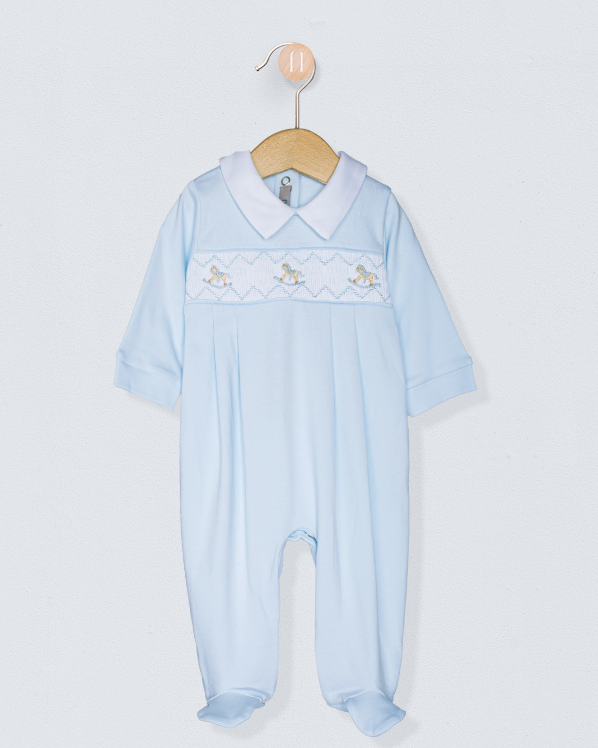 Light blue baby romper with embroidered details on a white background