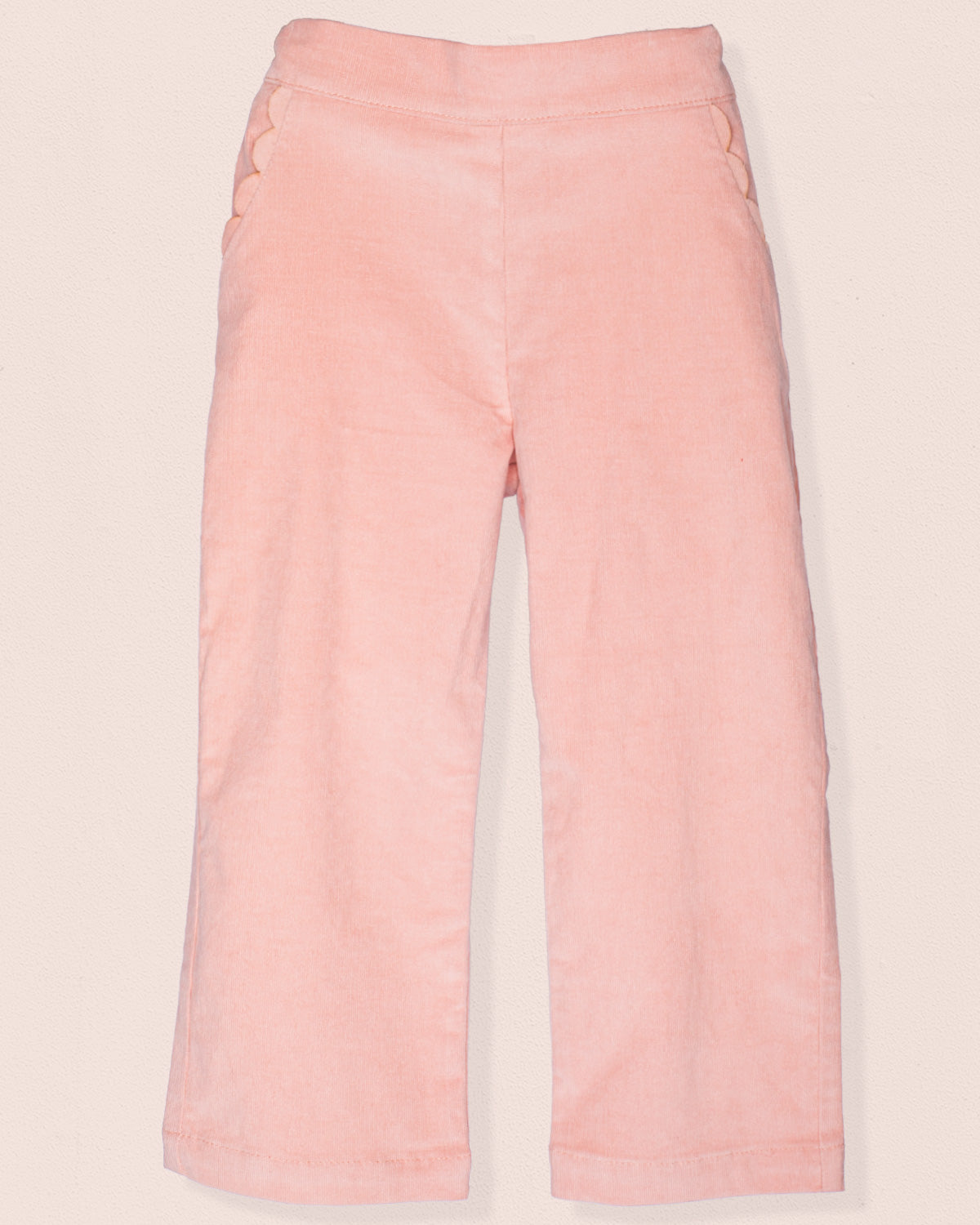 Front view of ruby pink Italian corduroy pull-on pants with scalloped front pocket detailing.