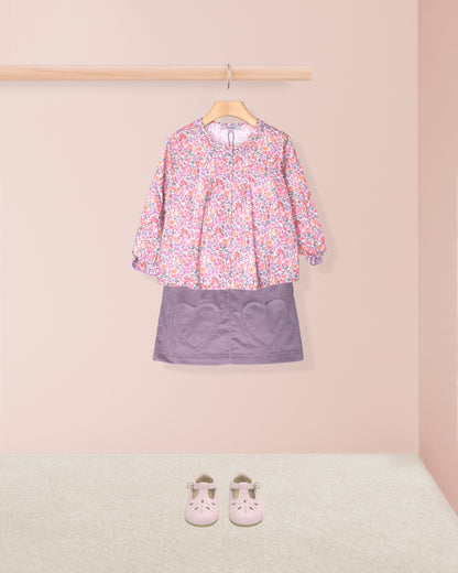 tunic and skirt outfit in dressing room with pink shoes