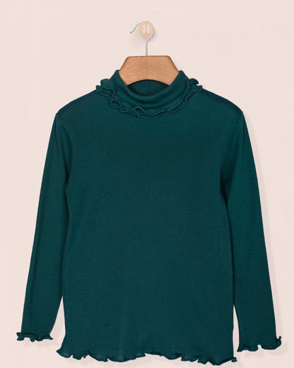 Hunter green Italian brushed cotton turtleneck for girls, displayed on a wooden hanger against a neutral background. Features ruffle trim on the neck and cuffs, with a soft, lightweight finish.