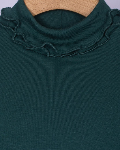 Close-up view of the ruffled turtleneck collar on the hunter green cotton top, showcasing the fine stitching and soft brushed fabric texture.