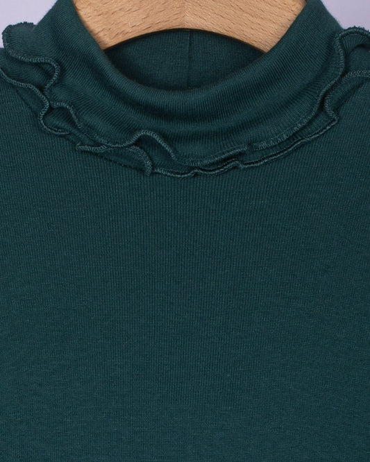 Close-up view of the ruffled turtleneck collar on the hunter green cotton top, showcasing the fine stitching and soft brushed fabric texture.
