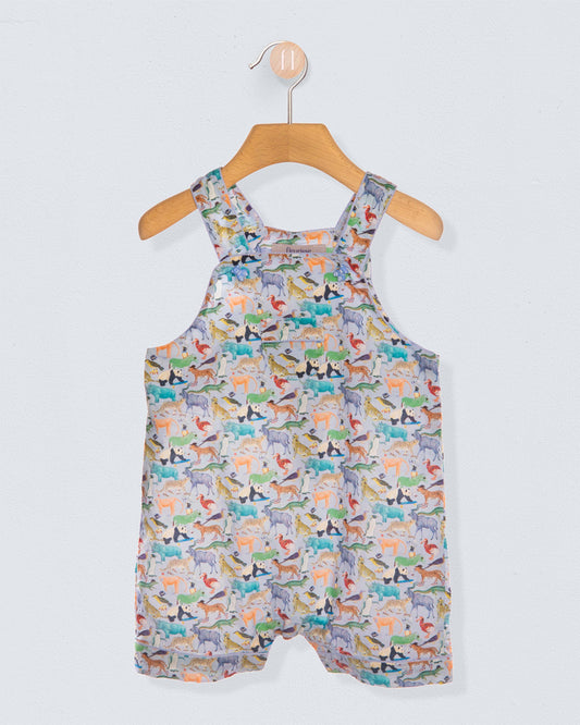 Front of children's shortalls with animal pattern on a hanger against a light gray background