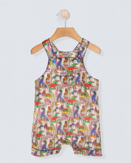 Front of Colorful dinosaur-patterned shortall on a hanger against a light gray background