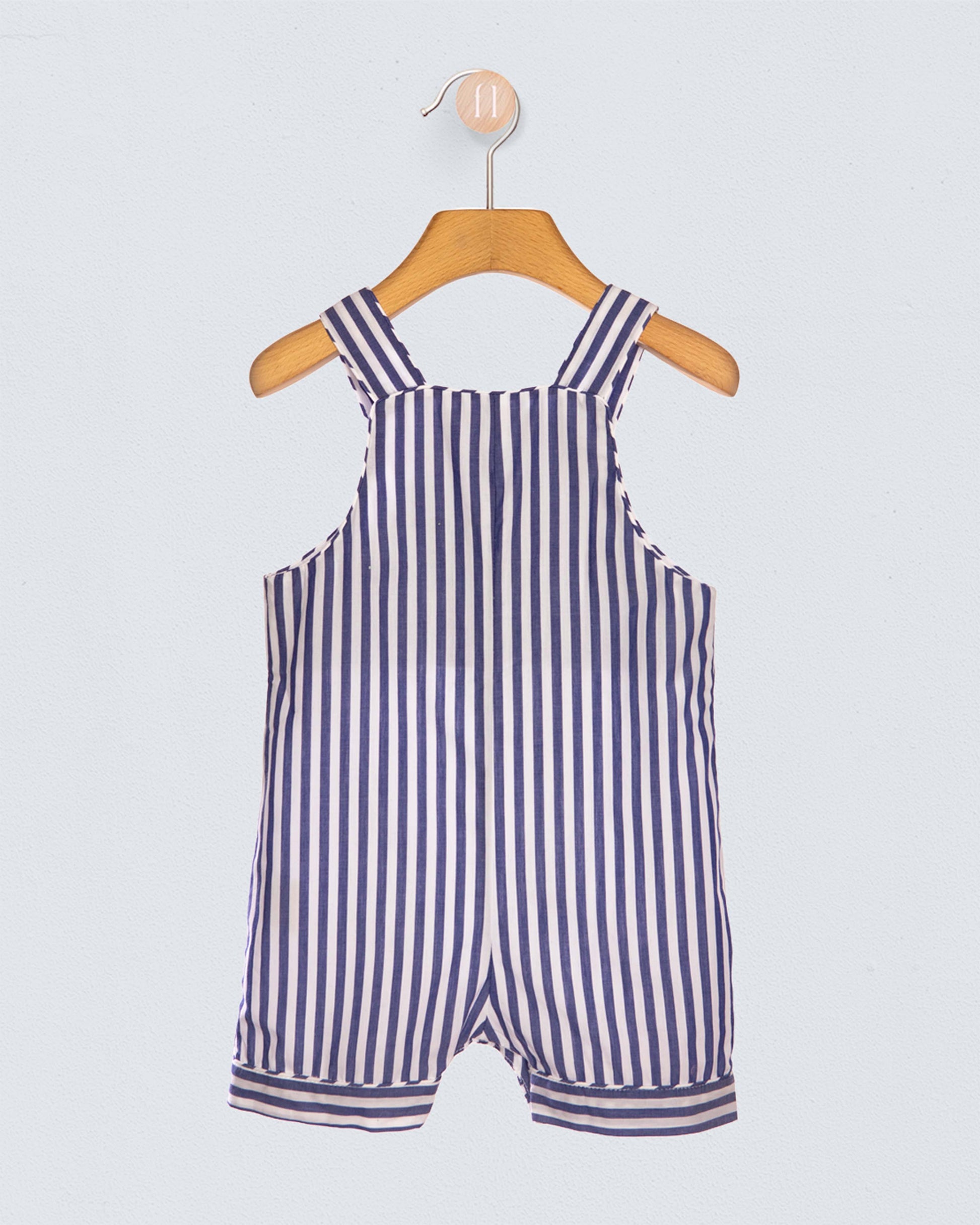 Navy and white striped romper on a wooden hanger against a light gray background
