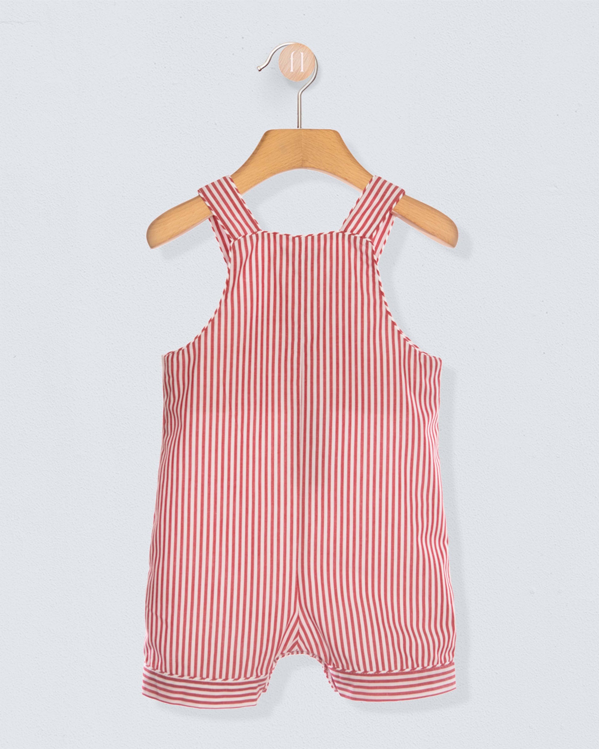 Back of red and white striped shortall on a wooden hanger against a light gray background