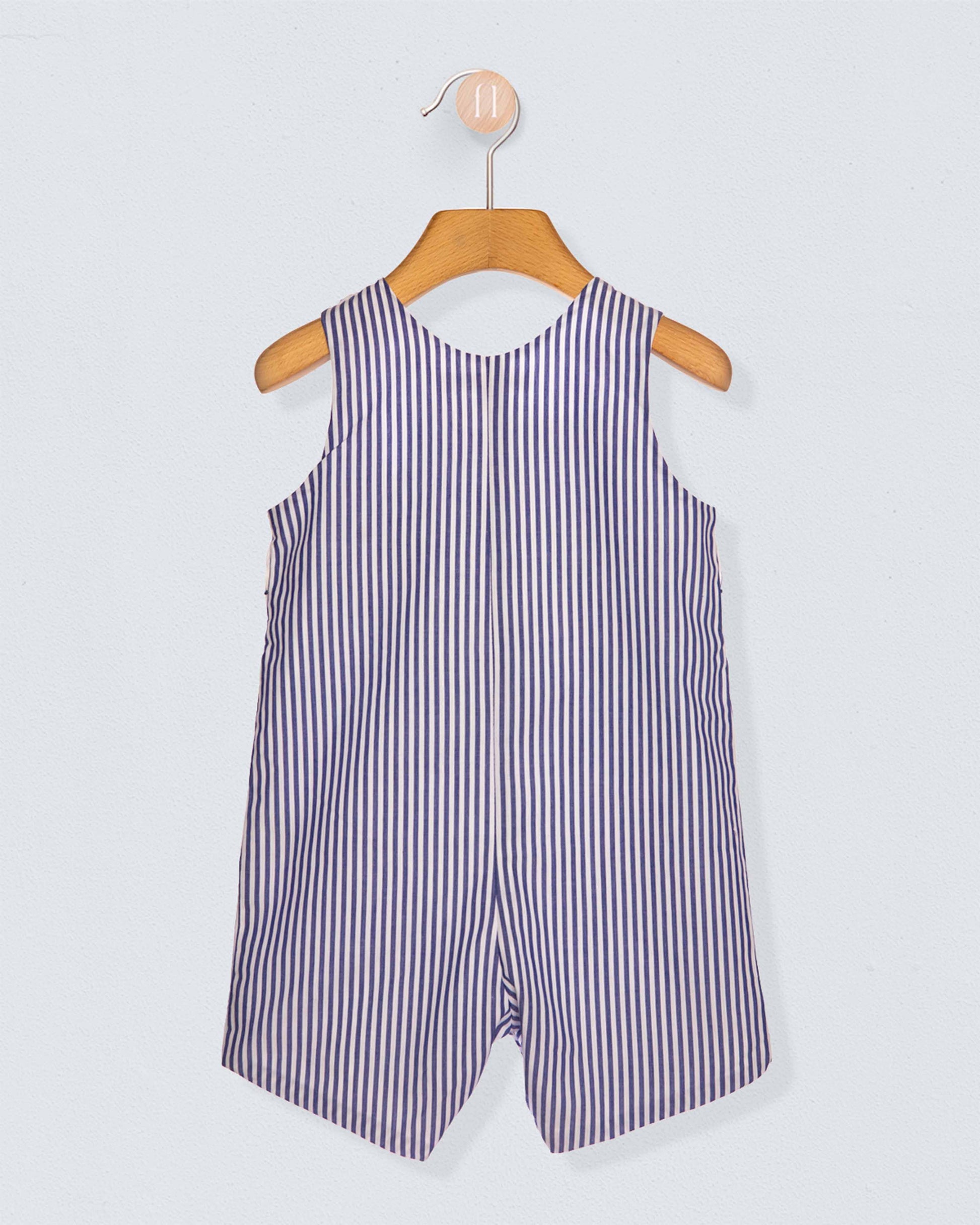 Back of striped romper on a wooden hanger against a light gray background