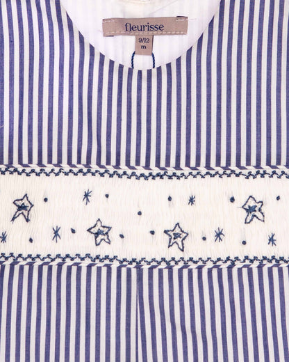 close up fabric of Blue and white striped dress with star patterns and 'fleurisse' label.