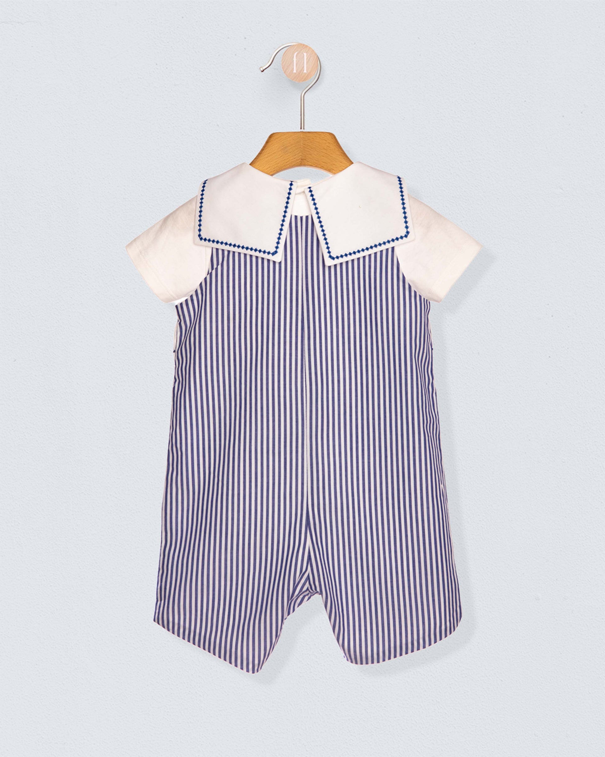 Back of children's outfit with striped romper and white shirt on a light gray background