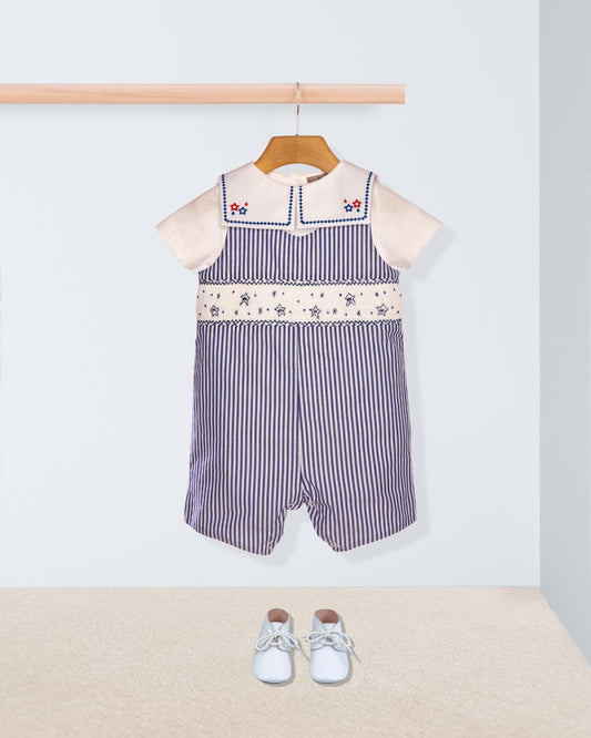 Striped baby romper with floral embroidery on a hanger against a light background