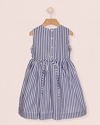 Blue and white striped dress on a hanger against a beige background