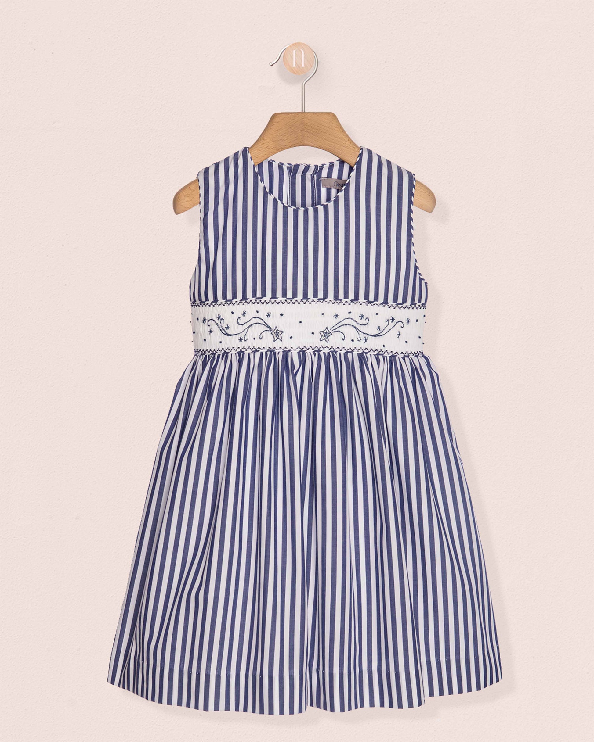 Blue and white striped dress with floral embroidery on a beige background