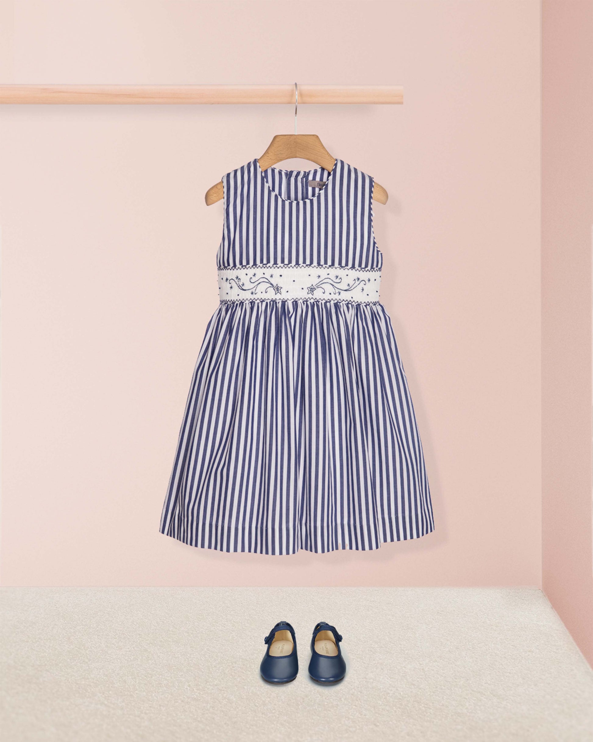 Navy striped dress with lace detail on a pink background