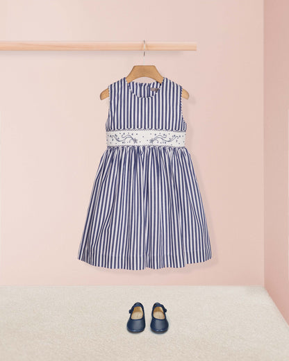 Navy striped dress with lace detail on a pink background