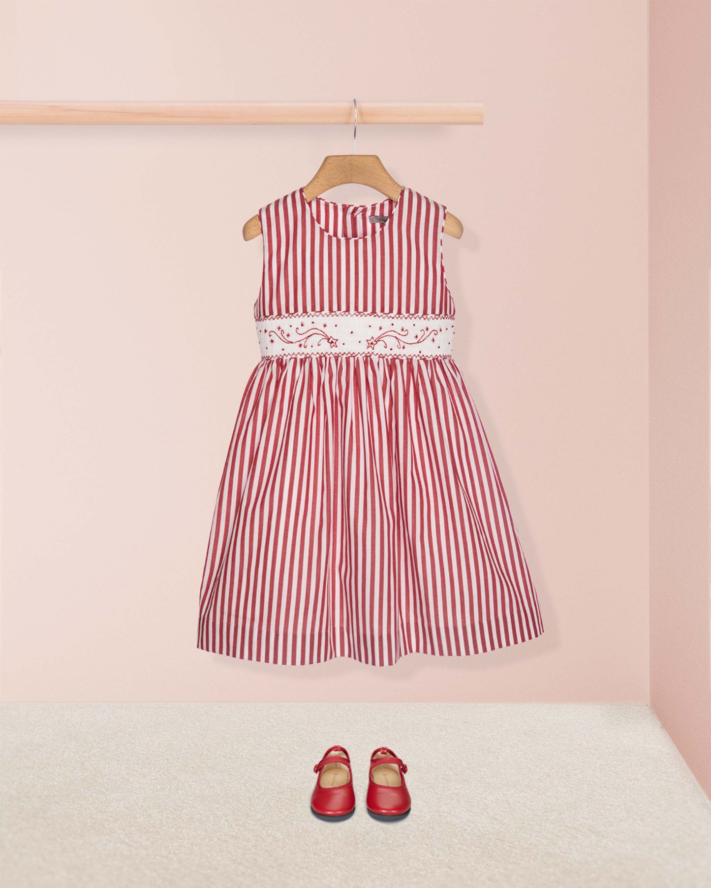 Red and white striped dress with lace detail on a pink background