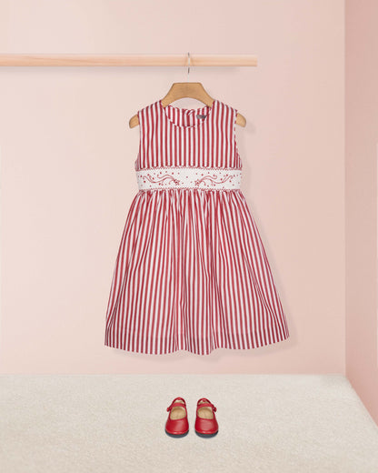Red and white striped dress with lace detail on a pink background