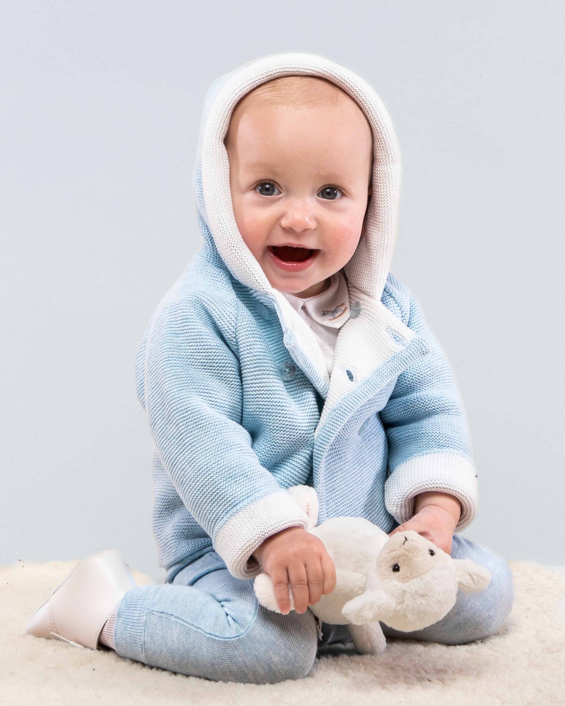 Jackpot Light Blue Hooded Sweater on baby sitting on floor holding sheep toy