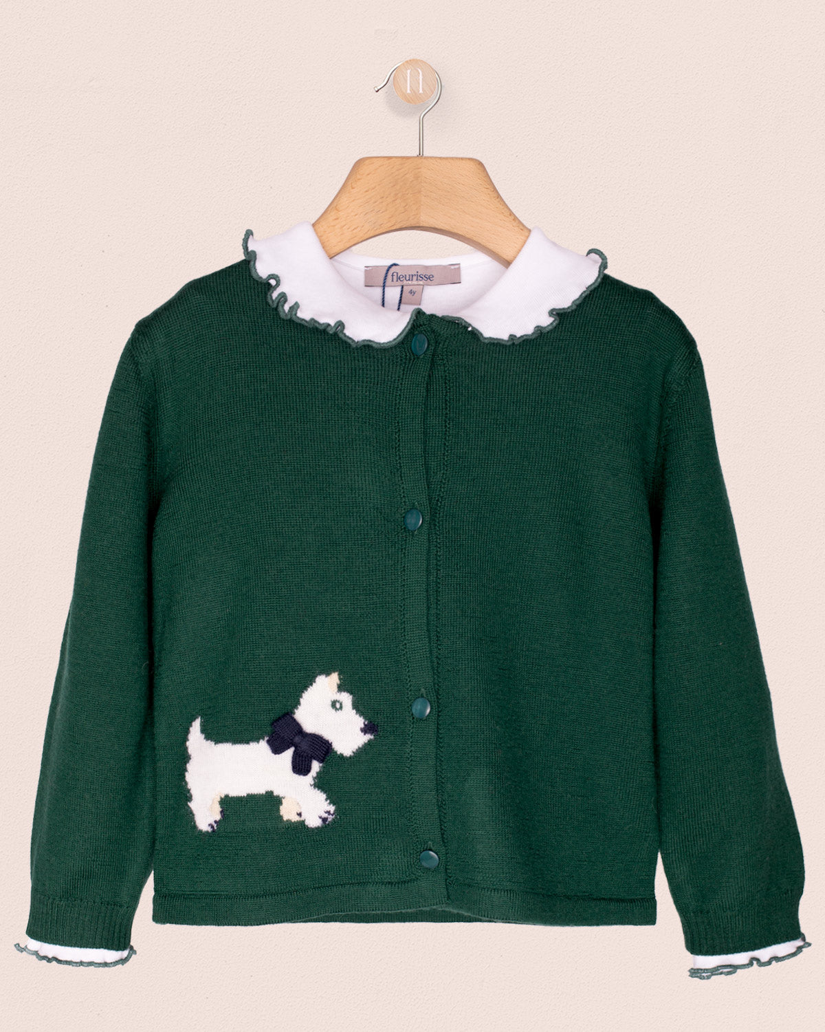 Green cardigan with white dog design on a beige background