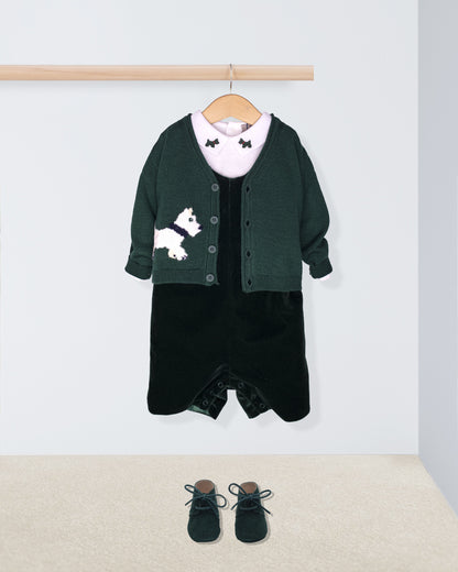 Children's outfit with green cardigan, black dress, and shoes on a white background