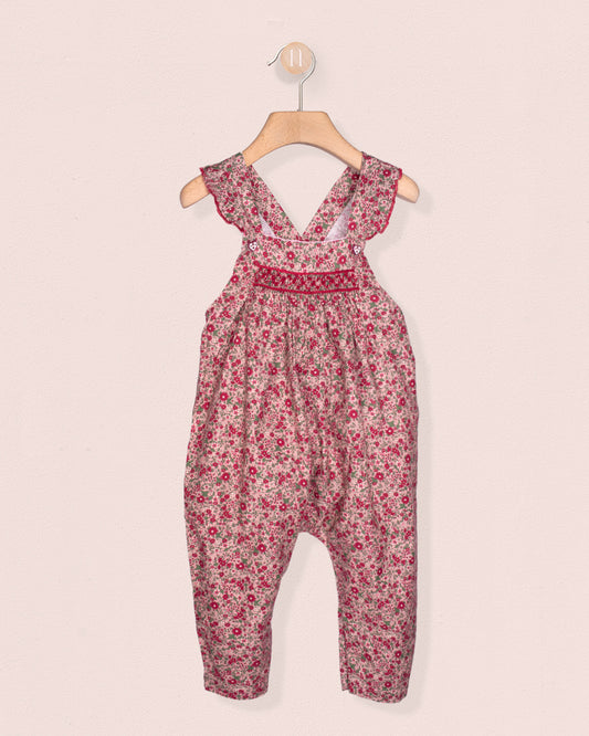 Floral-patterned jumpsuit on a hanger against a light pink background