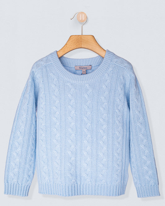 Light blue cable knit sweater on a wooden hanger against a light gray background