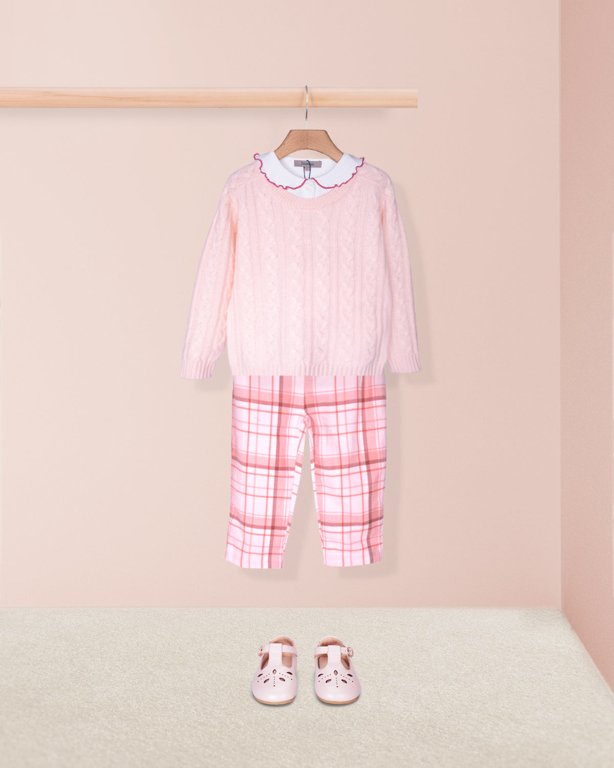 Pink outfit with plaid pants and matching shoes on a beige background
