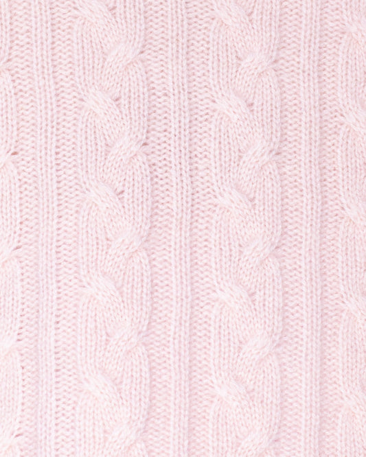 Close-up of pink knitted fabric with cable pattern