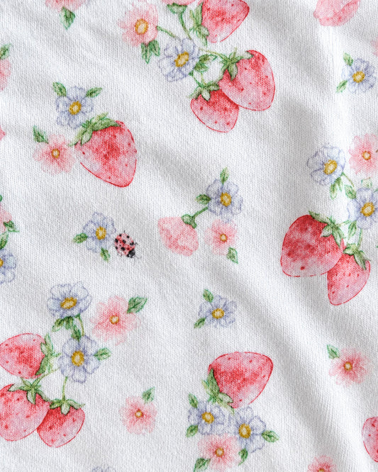 Closeup of white fabric with pink strawberries, light blue flowers with yellow centers and green stems, repeatable motif across the fabric.