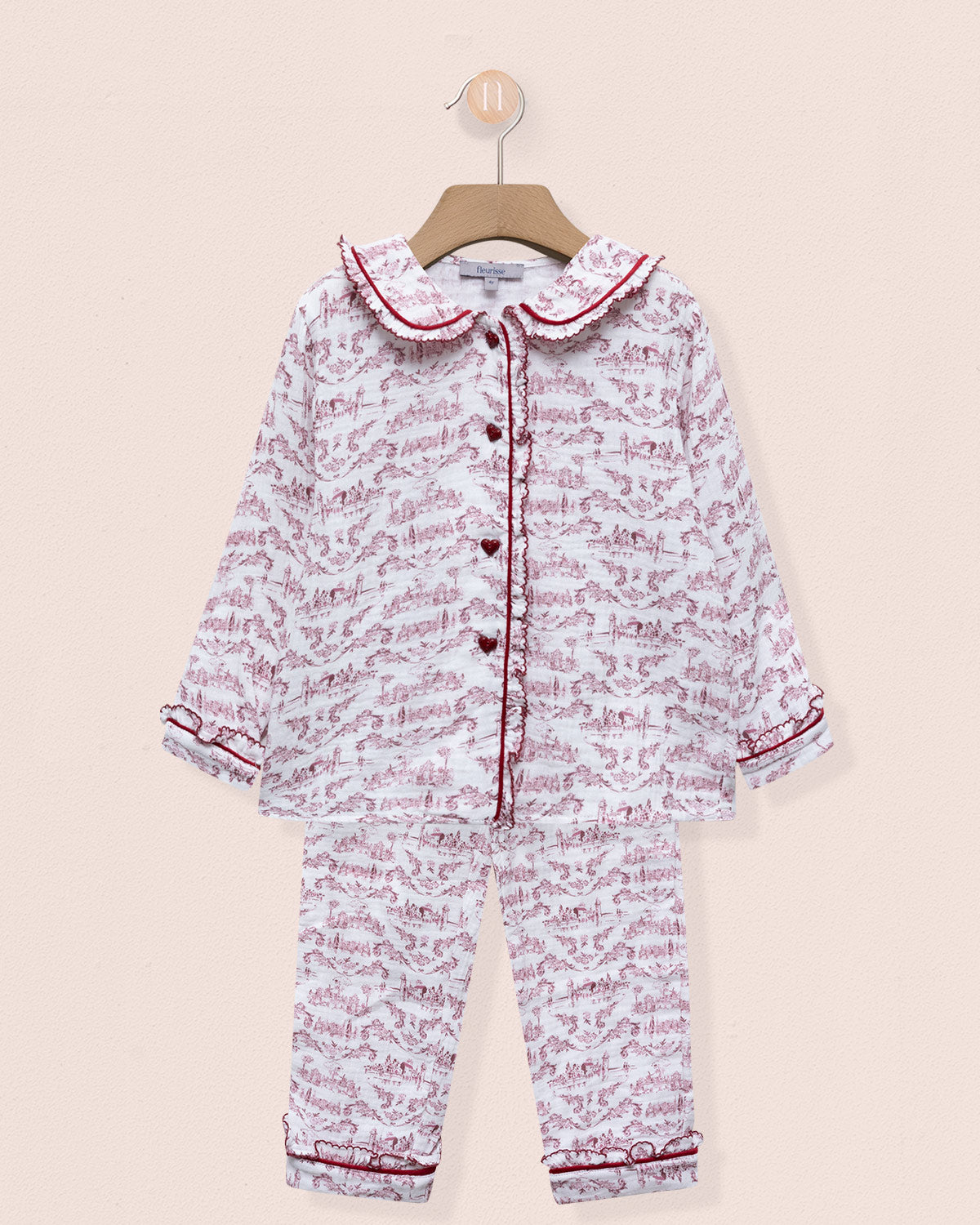 Children's pajama set with pink and white pattern on a beige background
