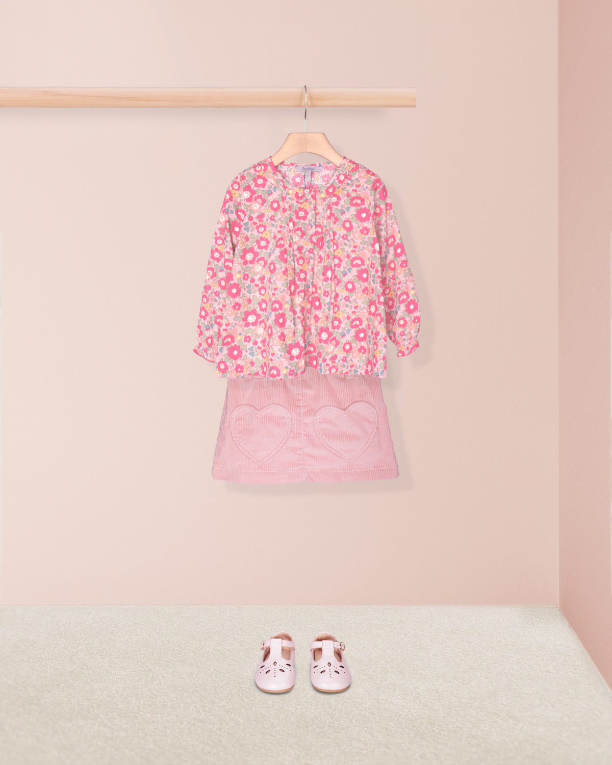 Pink floral top and skirt set with matching shoes on a pink background