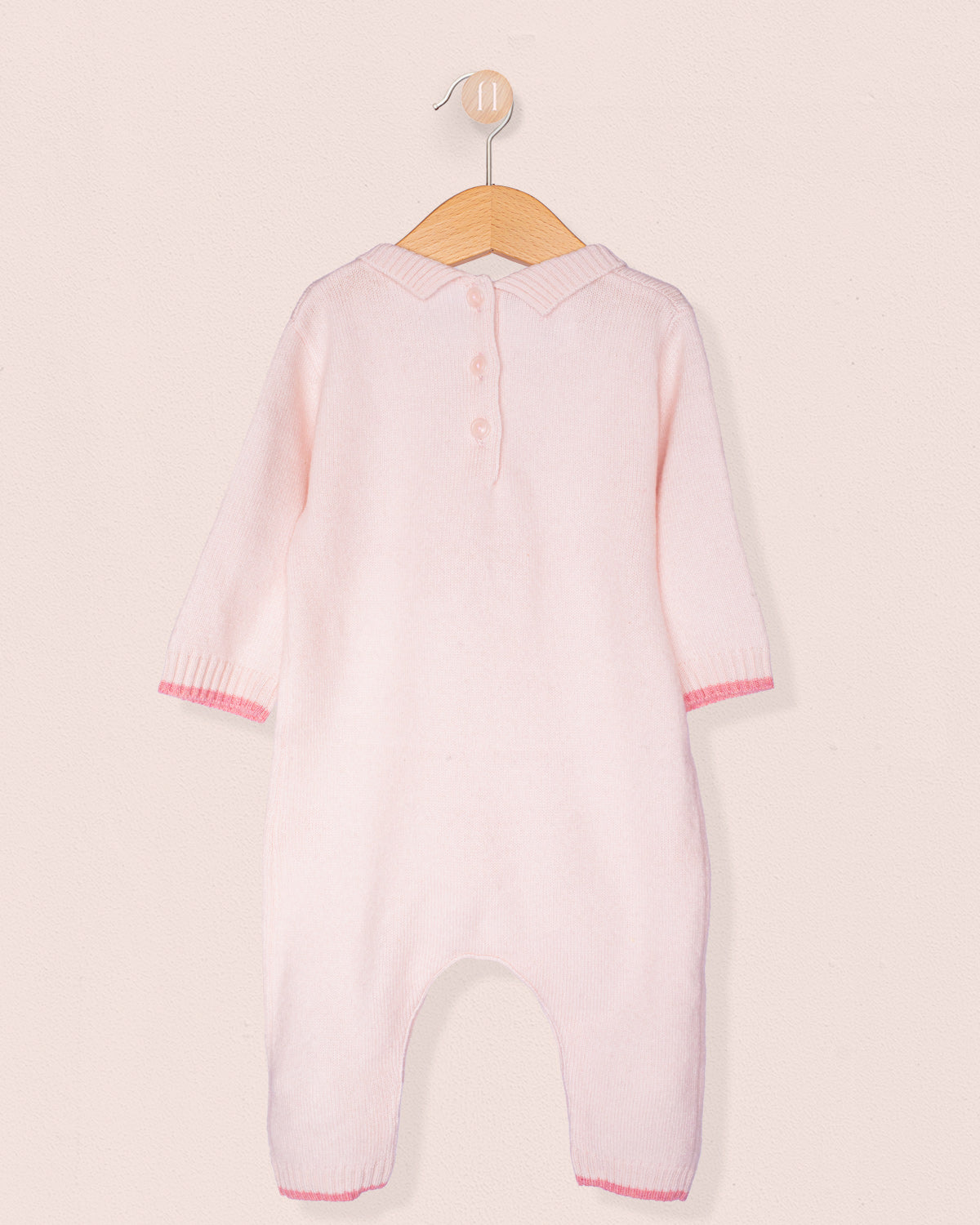 Back of baby onesie with 3 buttons on a hanger, with white background