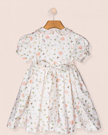 Back view of the Valentina dress showing the button closure, waist tie bow, and all-over floral print, emphasizing craftsmanship and silhouette detail.