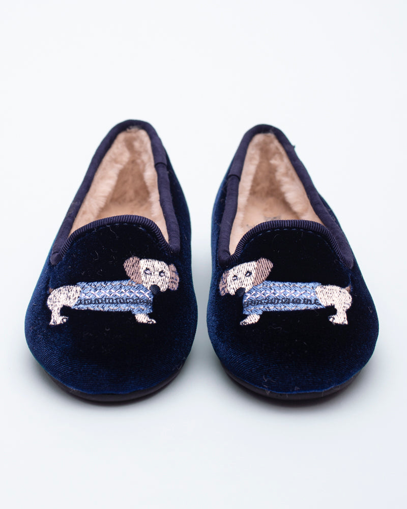 Pair of navy blue slippers with embroidered dachshund design on a white background