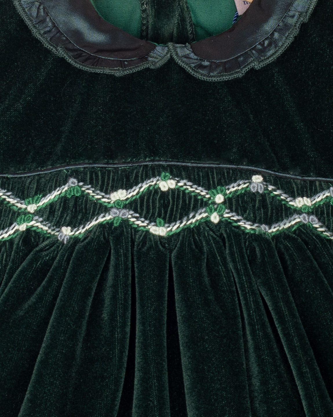 Close-up of a green velvet garment with intricate beadwork