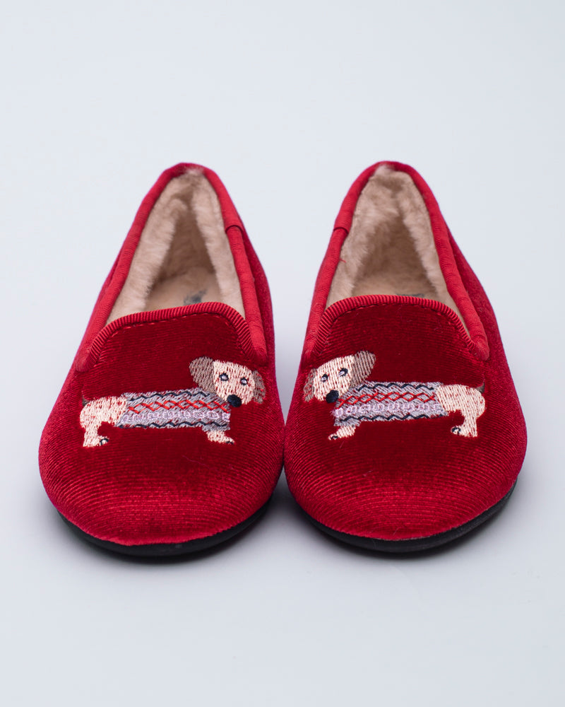 Red slippers with embroidered dachshund dogs on a light gray background