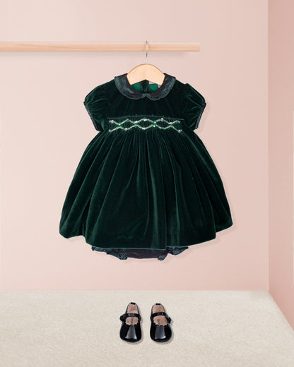 Green velvet dress with black shoes on a pink background
