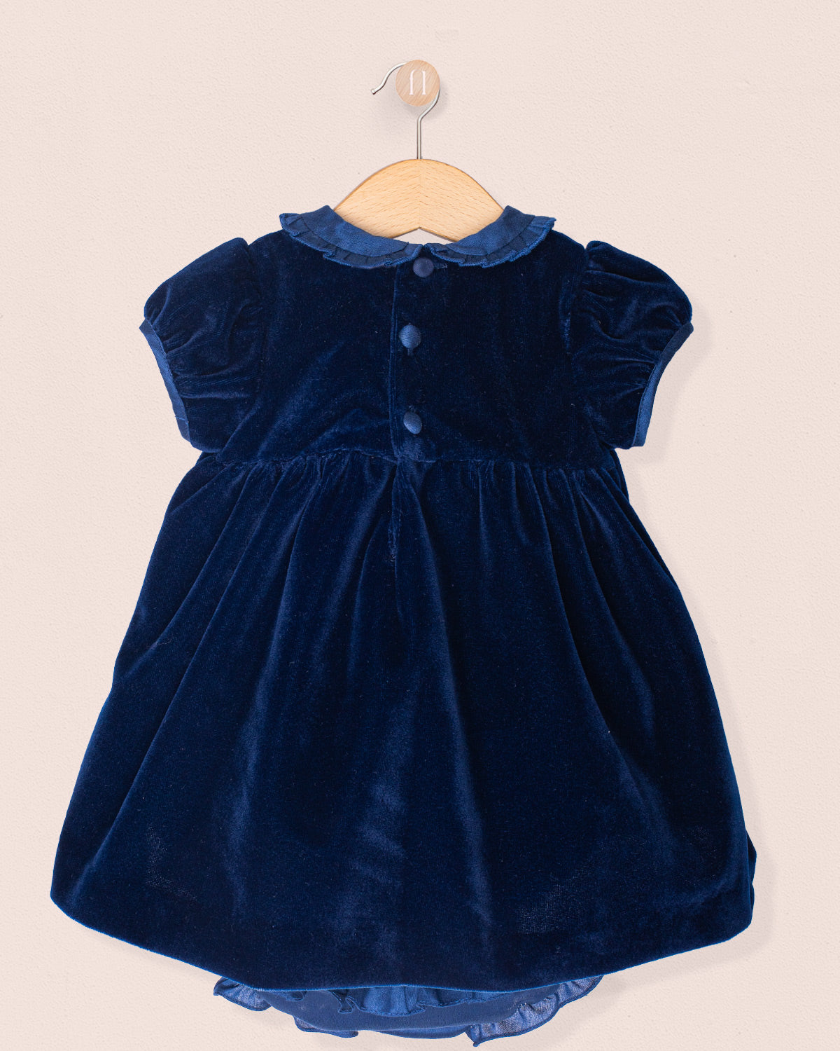 Navy blue velvet dress on a beige background