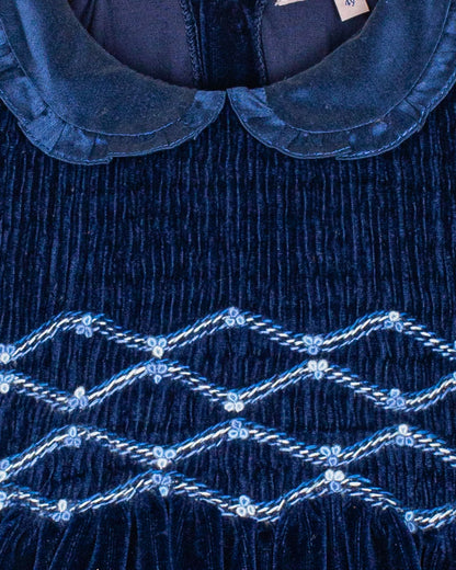 Close-up of a navy blue velvet with intricate smocking
