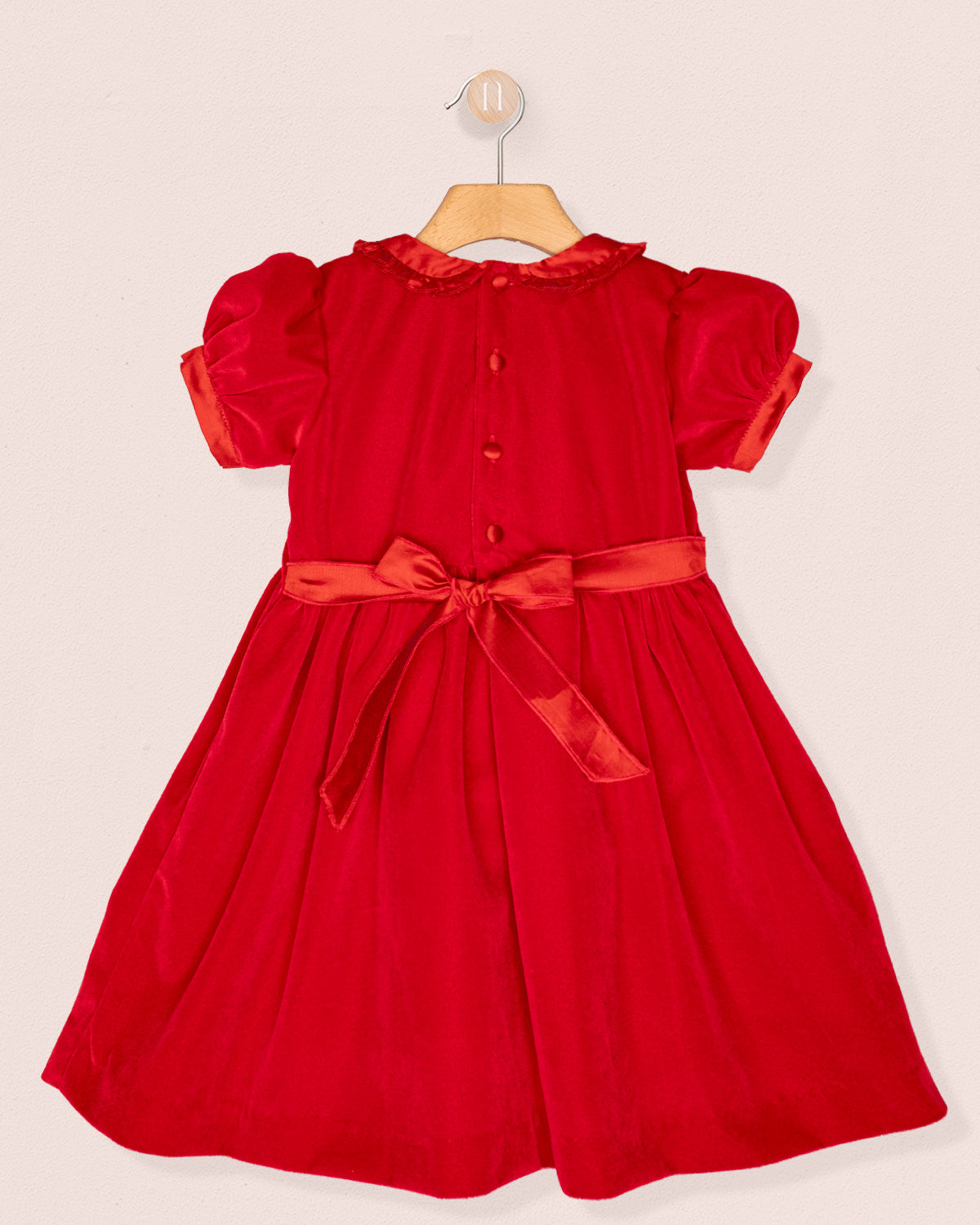 Red dress with a bow sash on a beige background back view