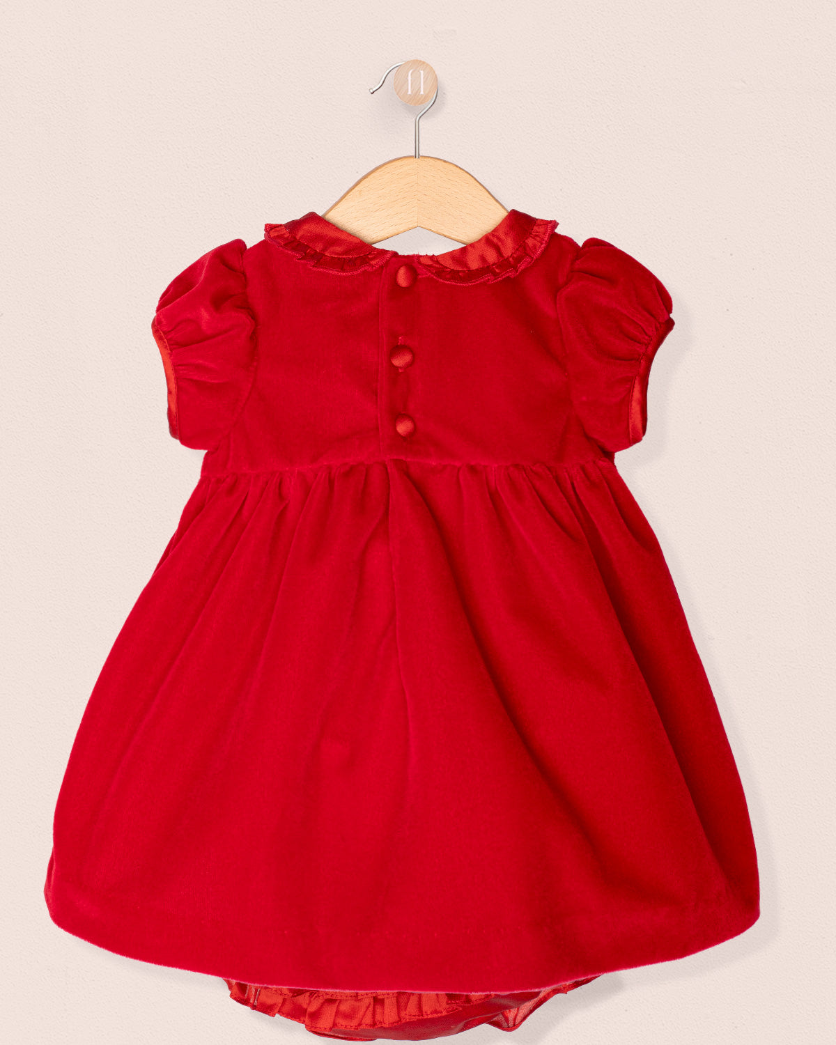 Red dress on a hanger against a beige background